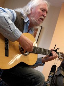 Seoirse Ó Dochartaigh playing guitar